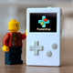 The PocketStar handheld console posed next to a Lego minifigure toy.